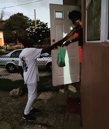 A bag of essentials handed over at a front door